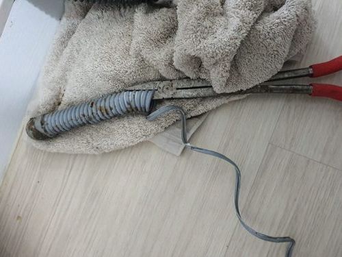 영통구 하수구막힘 싱크대 하부 배수 연결부의 누수 흔적을 살피는 모습